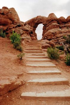 there is a set of steps leading up to an arch in the rock formation that looks like it has been built into the ground