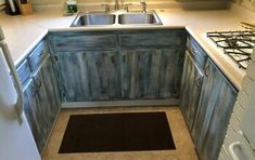 a kitchen area with sink, stove and cabinets in the corner next to an oven