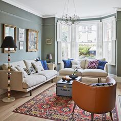 a living room with two couches and a rug in front of the windows,