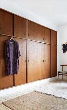 a bedroom with wooden closets and a rug on the floor in front of it