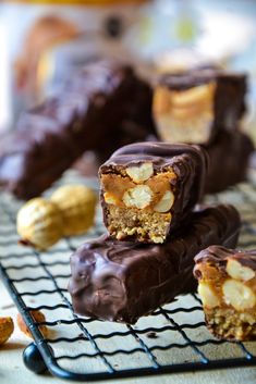 chocolate and peanut butter bars on a cooling rack with nuts in the background, ready to be eaten