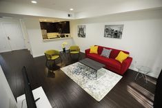 a living room filled with furniture next to a kitchen and dining room table on top of a hard wood floor