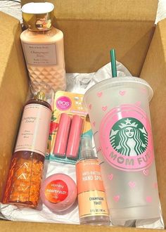 an open starbucks cup sitting on top of a table next to other items in a box