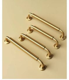 four brass plated screws on a beige background