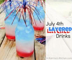 patriotic drinks are sitting on a picnic table with the words july layered drinks written in red, white and blue