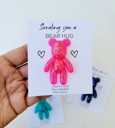 someone is holding a pink and blue teddy bear brooch