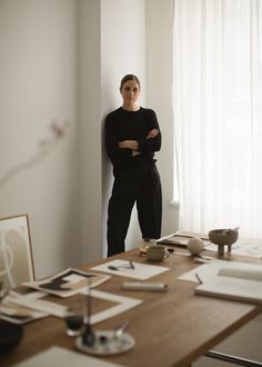 a woman standing next to a table with pictures on it