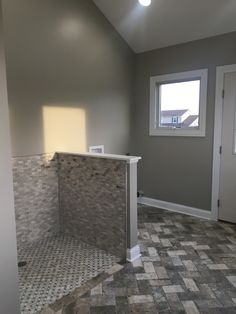 an empty room with tile flooring and walls in the background, there is a window on the far wall