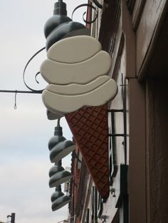 an ice cream cone hanging from the side of a building