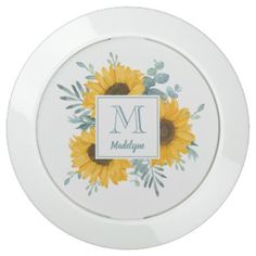 a white plate with sunflowers and the letter m on it's side