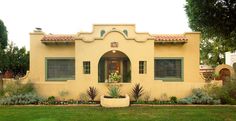 an adobe style house with plants in the front yard