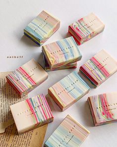 small soap bars with colorful stripes on them sitting on top of an open book next to each other