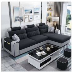 a modern living room with black and white couches, coffee table and pictures on the wall