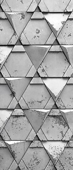 a black and white photo of a wall made up of triangles with paint chippings