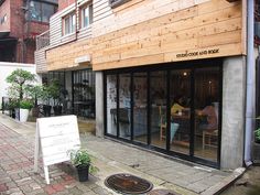 an outside view of a restaurant with tables and chairs on the sidewalk in front of it