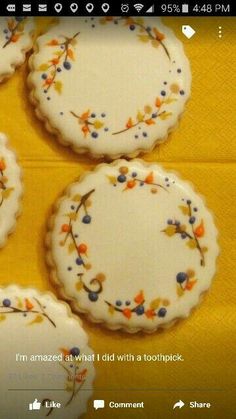 four decorated cookies sitting on top of a yellow table cloth with words written below them