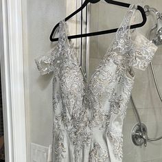 a dress hanging on a hanger in front of a shower