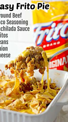 a casserole dish with ground beef and cheese being lifted from the casserole