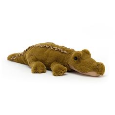 a stuffed alligator is laying down on the white floor with its head turned to the side