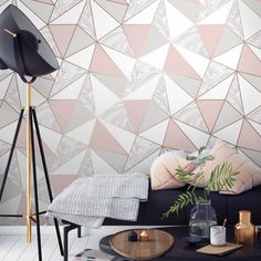 a living room scene with focus on the sofa and wallpapers that have been designed to look like triangles