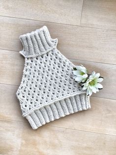 a crocheted sweater with a flower on the floor