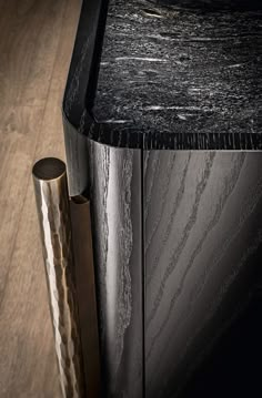 a black marble top sideboard with two metal tubes sticking out of it's sides