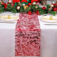 the table is set for christmas dinner with red and green decorations