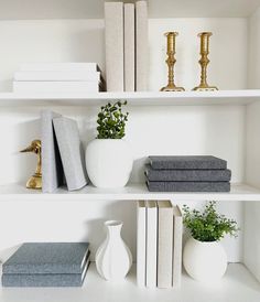 white shelves with books and vases on them