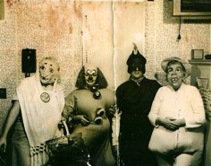 an old photo of three people dressed as clowns and one is wearing a cat mask