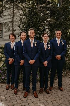 a group of men in suits standing next to each other on a brick floored walkway