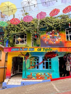 colorful buildings with umbrellas hanging from the roof