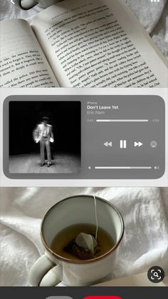 an open book on top of a bed next to a cup of tea