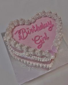 a heart shaped birthday cake with the words birthday girl written in pink frosting on it