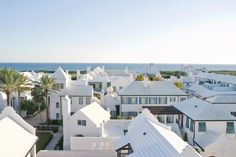 an aerial view of some white houses by the ocean