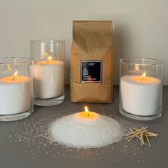 some candles are sitting on a table next to a bag