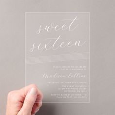 a person holding up a card with the word sweet sixteen on it in white ink