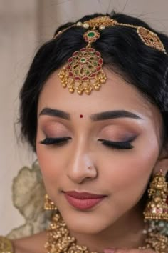 a woman with makeup and jewelry on her face