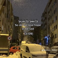 a snowy street with cars parked on the side and a quote written in two languages