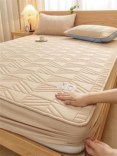 a person is placing their hand on the mattress