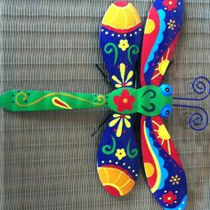 two colorful dragon shaped spoons sitting next to each other on top of a table