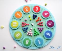 a close up of a colorful clock made out of felt with numbers and letters on it