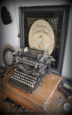 an old fashioned typewriter sitting on top of a wooden table