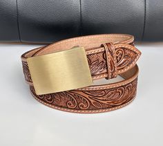 ➤Custom brass buckle with choice of engraving ➤100% full grain genuine leather. ➤Custom engrave option. ➤Belt thickness  3.2 mm -  1/8" thickness ➤ 1-1/2" WIDE ➤ Easy Snap System for Interchanging Buckles Personalized Belt that serves as a great gift for your loved one. You can choose to personalize this belt, making it an Engraved Belt. This is a handmade western leather belt.  Tooled Western Floral Engraved Leather Belt 100% Genuine Full Grain Cowhide with Snaps 1-1/2" WIDE Classic Hand Tooled Leather Belt Buckles, Western Gold Leather Belt, Classic Embossed Leather Belt Buckles, Adjustable Engraved Brown Belt, Formal Adjustable Engraved Belt, Engraved Leather Belt Buckles, Adjustable, Custom Engraved Leather Belt Buckles, Engraved Leather Adjustable Belt Buckles, Adjustable Engraved Leather Belt Buckles