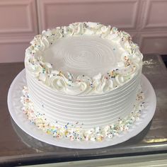 a cake with white frosting and sprinkles