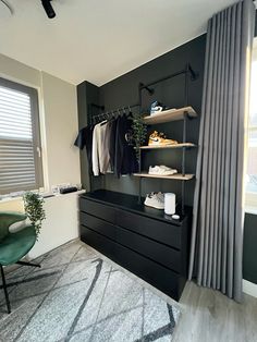 a bedroom with black walls and white carpeted flooring next to a large window