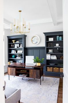 an office with built in bookcases and a large mirror on the wall above it