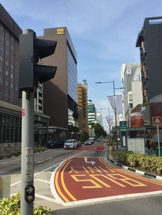 a traffic light sitting on the side of a road next to tall buildings and trees