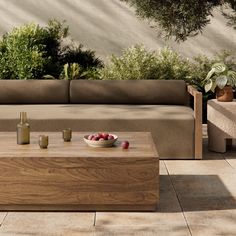 a wooden table sitting on top of a patio next to a couch and coffee table