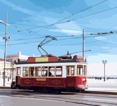 a red and white trolley car traveling down a street next to power lines on a cloudy day