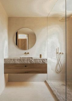 a bathroom with a sink, mirror and stand up shower in the middle of it